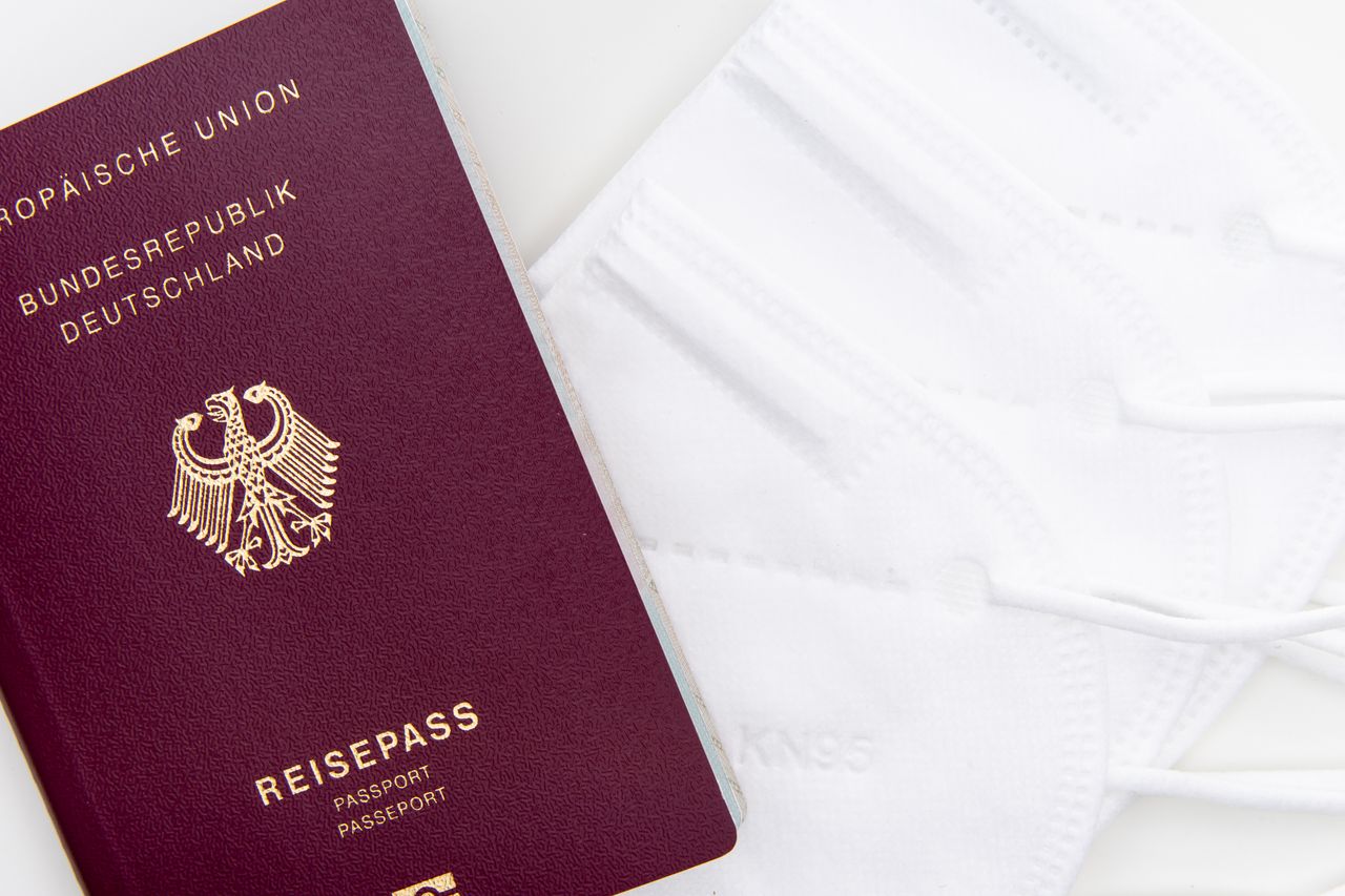 services-01 Close-up of a German passport and KN95 masks symbolizing travel during the pandemic.