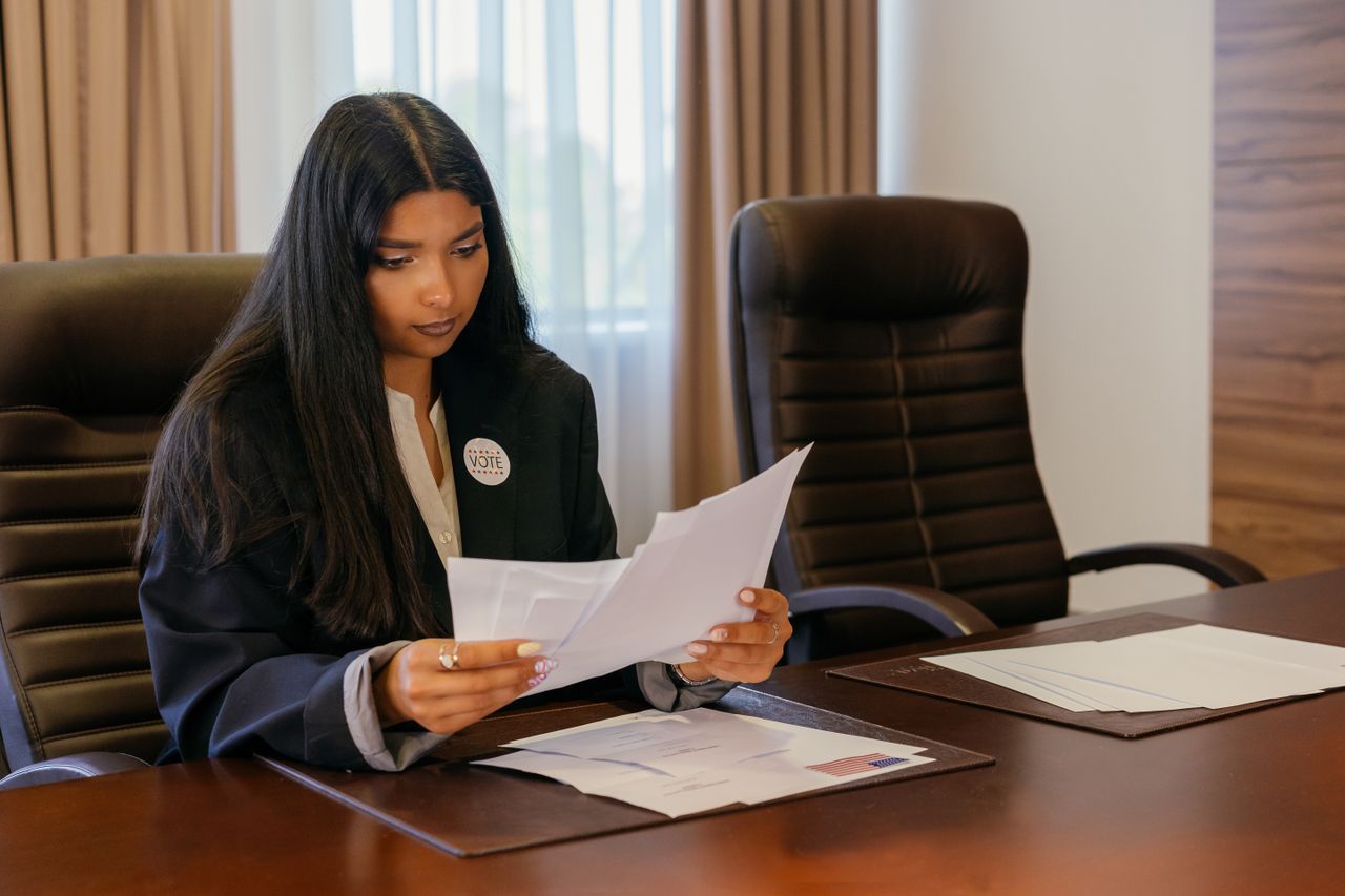 services-04 Professional woman in office analyzing important documents with a focus on political responsibilities.